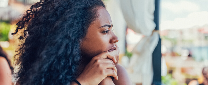 black woman looking out at a distance, visibly stressed