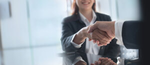 Business handshake. Business people making a handshake, close up. Two corporate businessman shaking hands during meeting in office