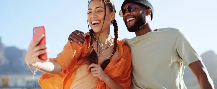 Couple, bonding and phone selfie on city building rooftop on New York summer holiday, travel vacation date or social media memory. Smile, happy or black man and woman on mobile photography technology